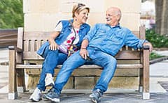 Senior couple sitting on a bech in a retirement community