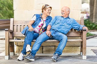 Senior couple sitting on a bech in a retirement community